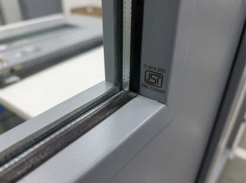 Close-up of KOR India fire door vision panel showing intumescent seals and ISI mark