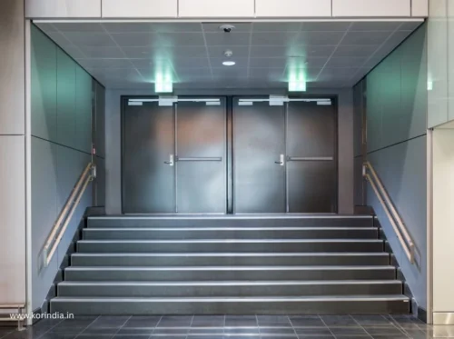 Professional installation of commercial fire doors in office building corridor showing proper NBC compliance
